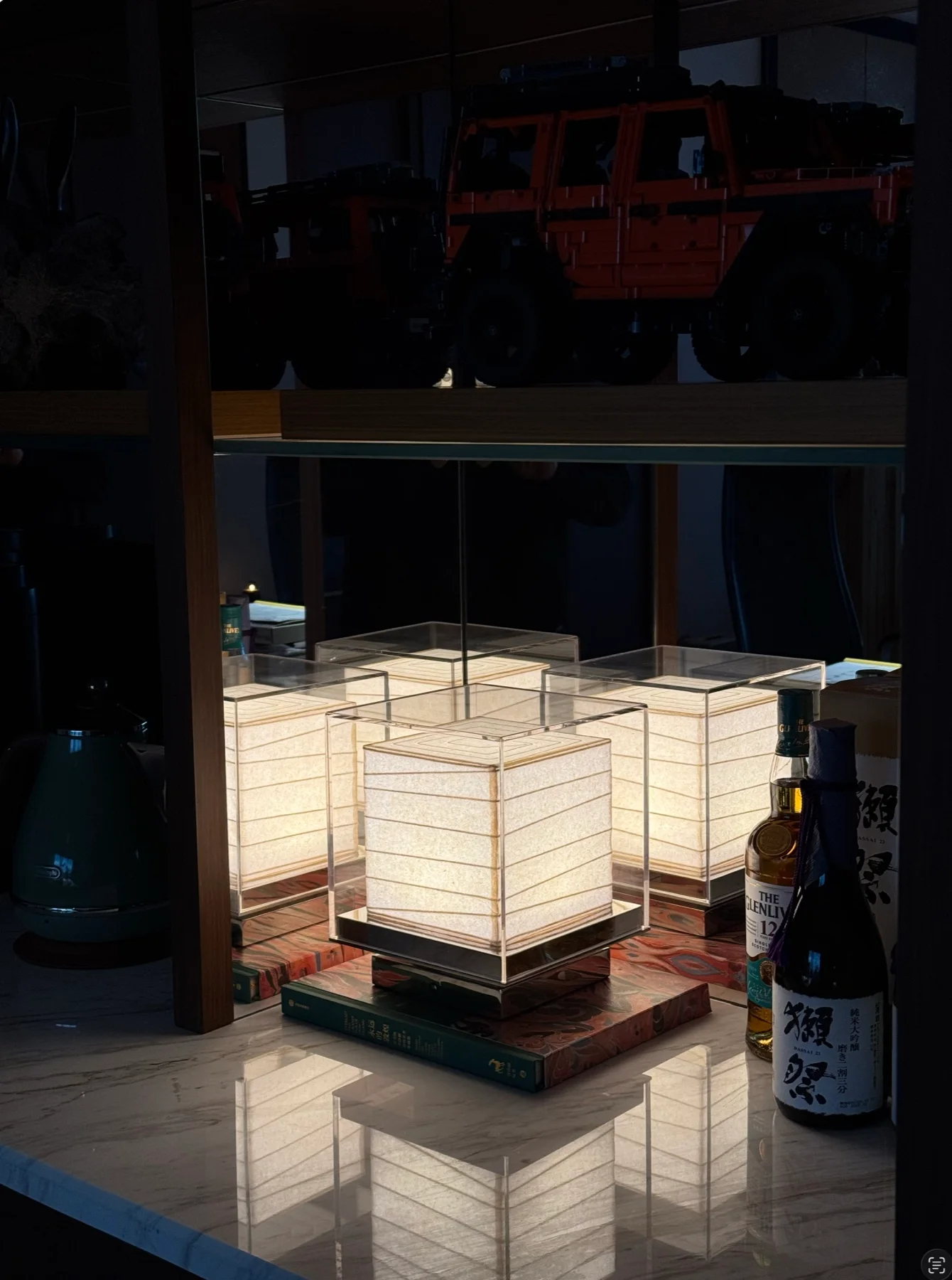 Illuminated square table lamps reflected on a stone counter