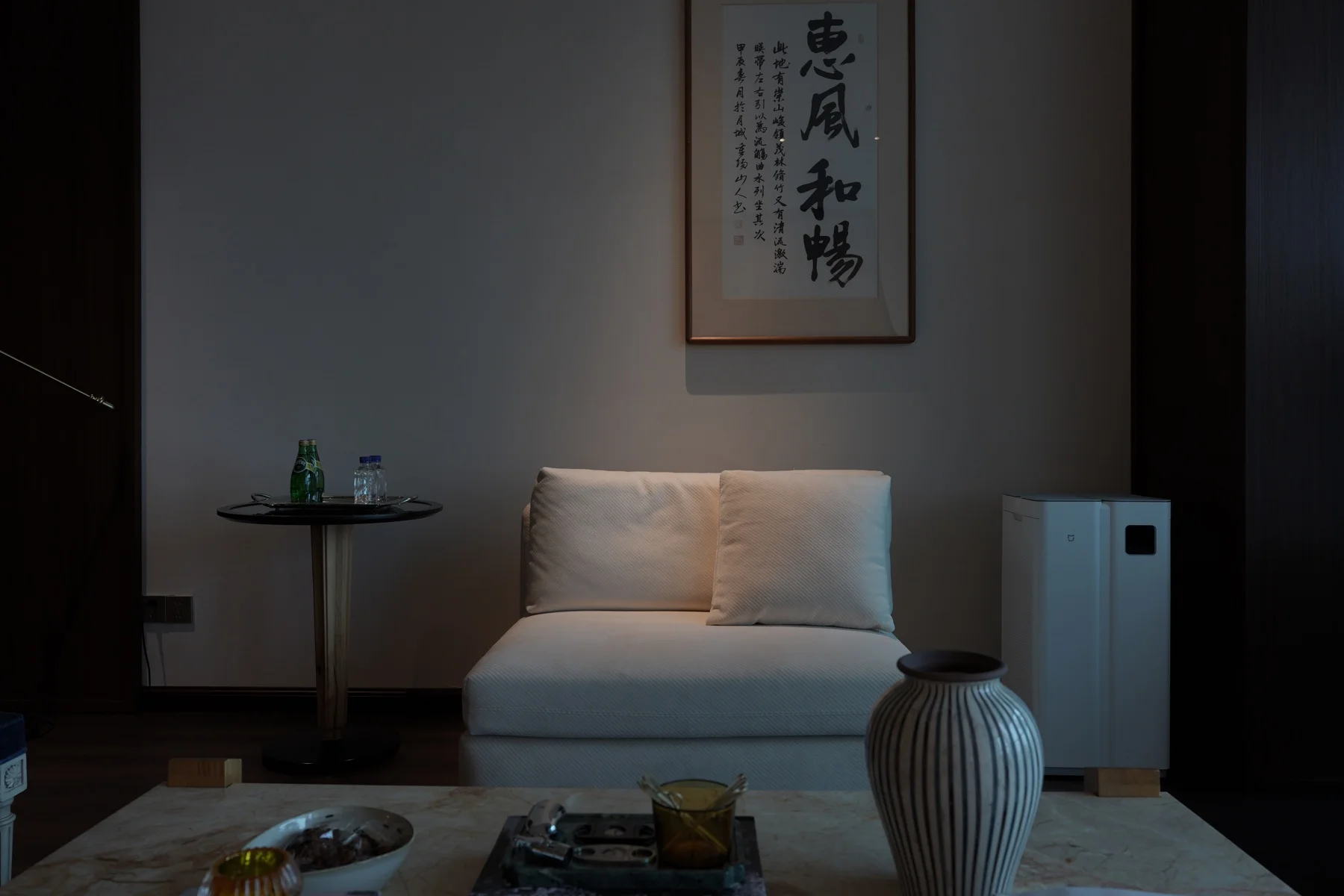 White lounge chair beneath Chinese calligraphy