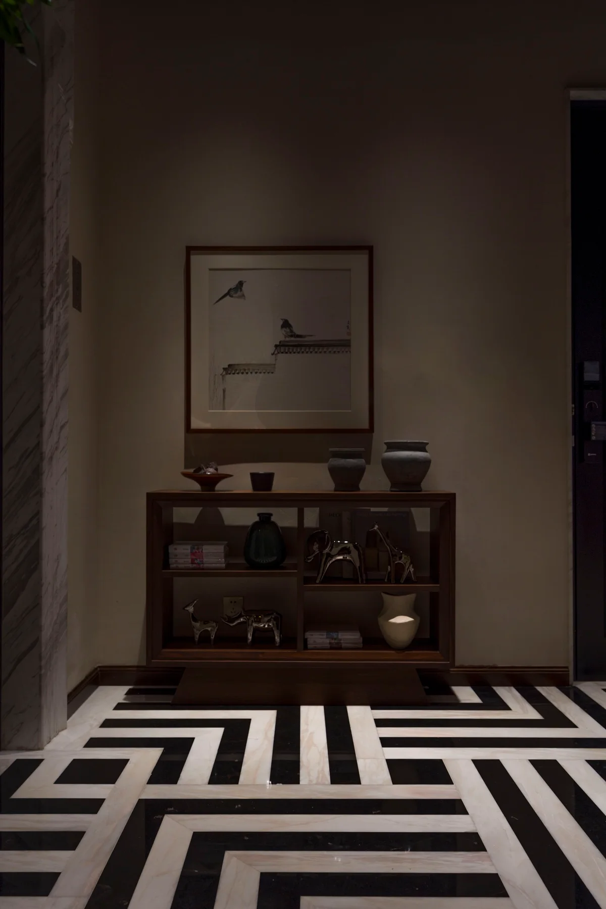 Dark timber console and framed bird artwork in a bespoke interior